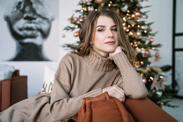 Blondes Mädchen mit langen Haaren in einem braunen Strickkleid