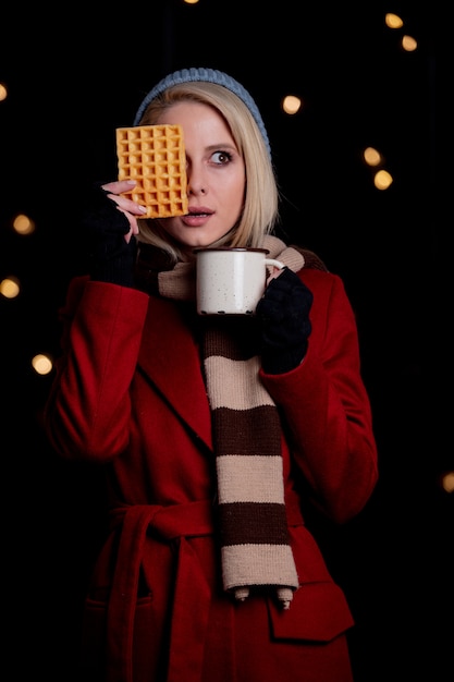 Blondes Mädchen mit Tasse Kaffee und Waffel