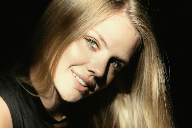 Blondes Mädchen, Nahaufnahme, Porträt einer eleganten Frau mit Licht auf schwarzem Hintergrund, schöne Frau