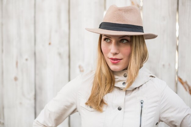 Foto blondes modell, das mit der hand auf hüften beim weg schauen aufwirft