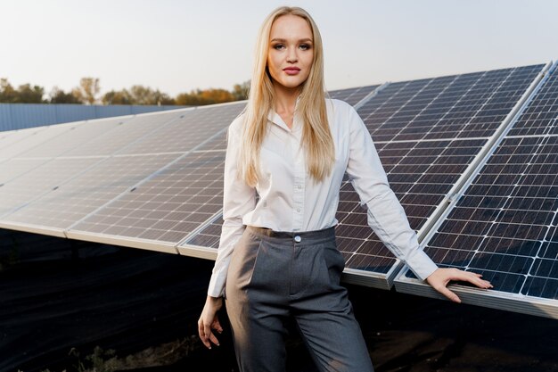 Blondes Modell mit Sonnenkollektoren steht in Reihe auf dem Boden