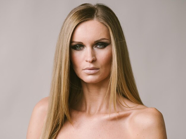 Blondes natürliches Porträt des langen Haares der Schönheit mit Schönheitsmake-up. Studioaufnahme.