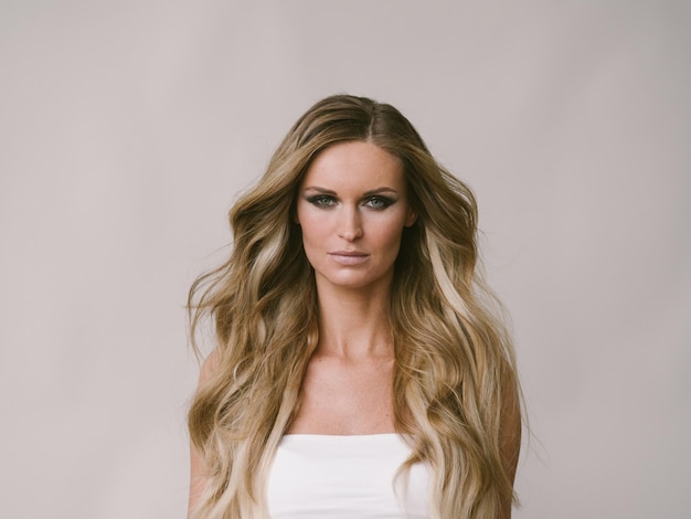Blondes natürliches Porträt des langen Haares der Schönheit mit Schönheitsmake-up. Studioaufnahme.
