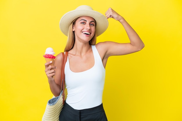 Blondes uruguayisches Mädchen im Sommer mit Eis isoliert auf gelbem Hintergrund mit starker Geste