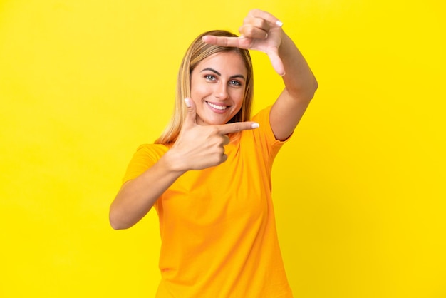 Blondes uruguayisches Mädchen lokalisiert auf dem Fokusgesicht des gelben Hintergrundes. Rahmensymbol