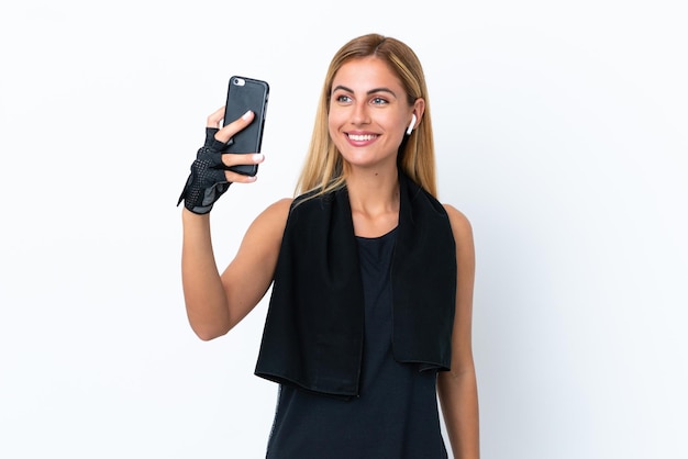 Blondes uruguayisches Sportmädchen lokalisiert auf weißem Hintergrund, der ein selfie macht