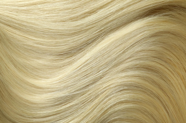 Blondes weibliches haar auf dem ganzen hintergrund, nahaufnahme
