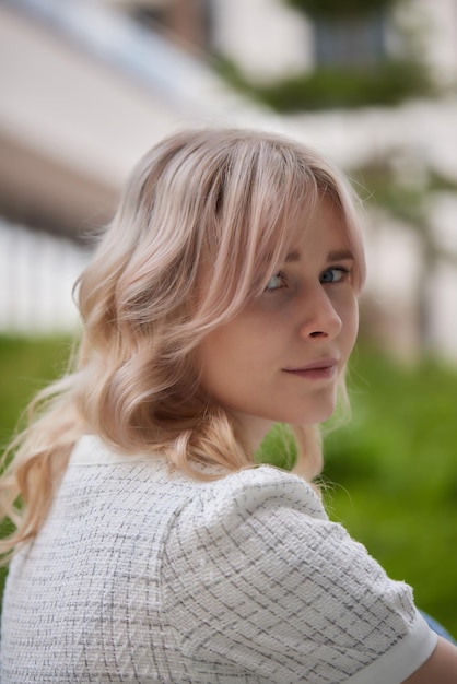 Blondie joven en vestido negro con pelo largo al aire libre retrato bastante alegre mujer caucásica