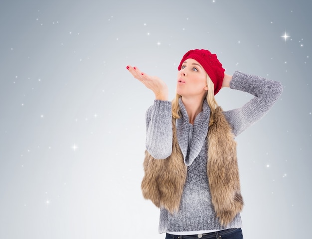 Blondine in der Winterkleidung, die Kuss durchbrennt