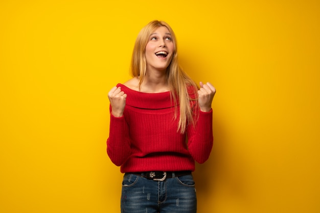 Blondine über der gelben Wand frustriert durch eine schlechte Situation