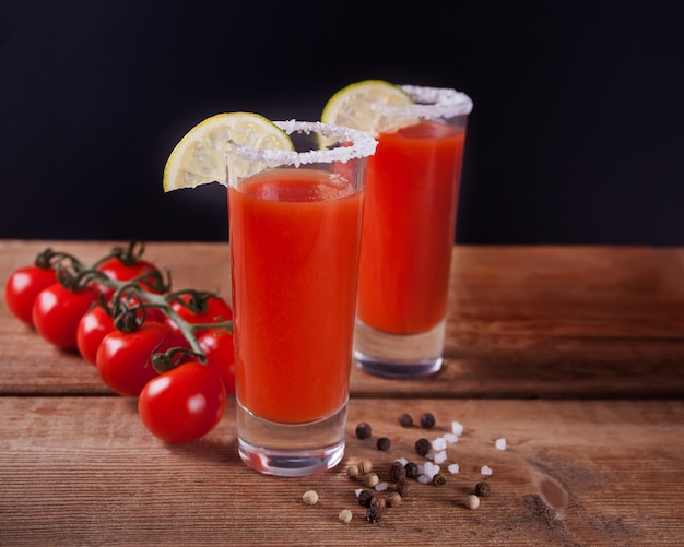 Bloody Mary Cocktail em copos. Bebida picante do Bloody Mary do tomate na tabela de madeira.