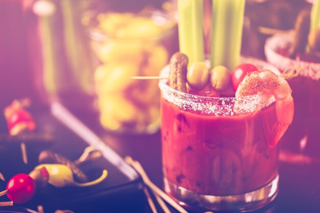 Bloody Mary Cocktail garniert mit Selleriestangen und Oliven.