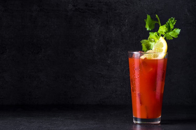 Bloody Mary cocktail en vidrio sobre negro, copia espacio