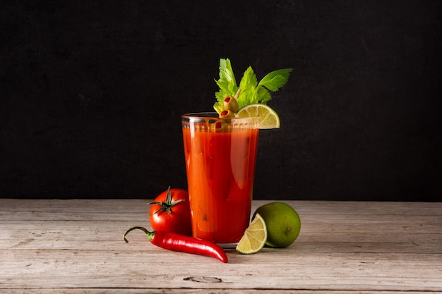 Foto bloody mary coquetel em vidro em uma mesa de madeira rústica