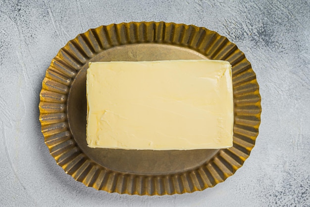 Bloque de mantequilla sobre placa de acero Fondo blanco Vista superior