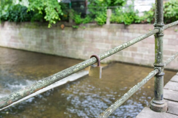 Bloqueio de ferrugem pendurar na ponte perto com o rio.