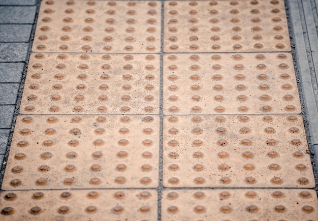 Bloques braille amarillos en la estación de transporte público para personas con discapacidad física