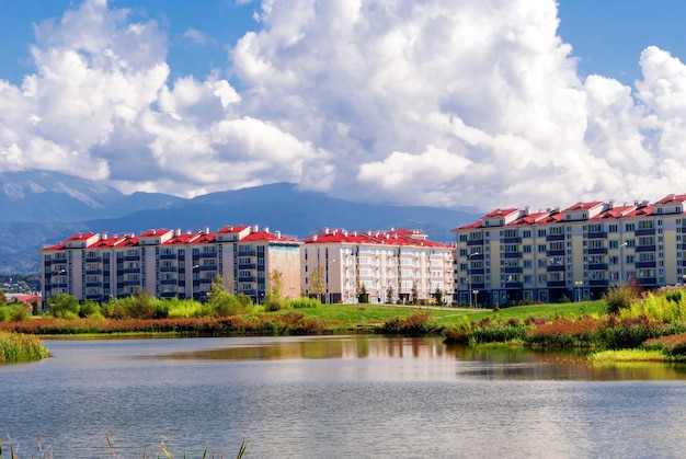 Bloques de la ciudad cerca del lago sobre un fondo de montañas