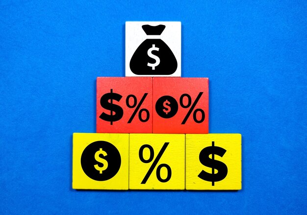 Foto bloques de colores con iconos de dinero y porcentaje el concepto de dinero está aumentando