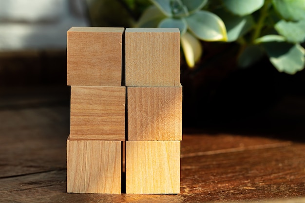 Bloques cuadrados de madera agrupados en la mesa de madera oscura, espacio de copia