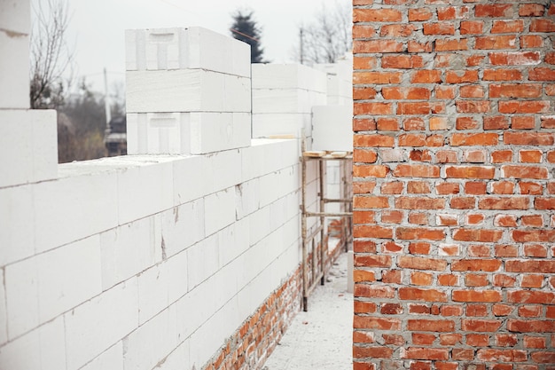 Bloques y ladrillos de hormigón celular esterilizados en autoclave de mampostería sobre cimientos de hormigón Colocación de paredes con bloques blancos Proceso de construcción de viviendas en el lugar de construcción