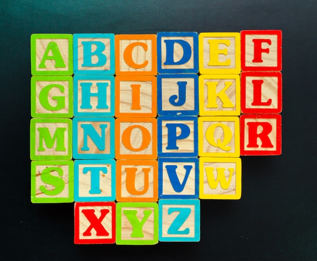 Bloques de madera del alfabeto con las letras en el tablero de madera