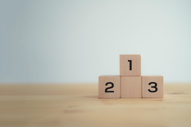 Bloques de madera apilados como un podio sobre un fondo blanco Objetivo de éxito ganar ganador victoria o el concepto de clasificación superior concepto de éxito empresarial concepto de educación concepto de competencia concepto