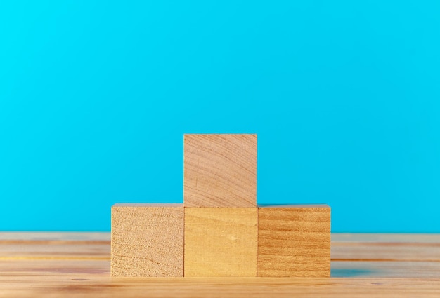 Bloques de madera apilados en un mostrador de madera contra el fondo azul.