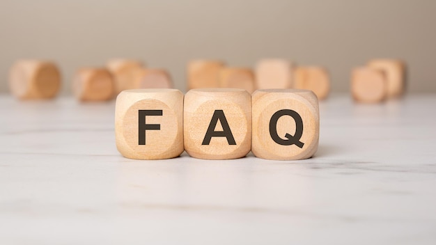Bloques de madera que forman la palabra faq en un fondo neutral que simbolizan las preguntas frecuentes