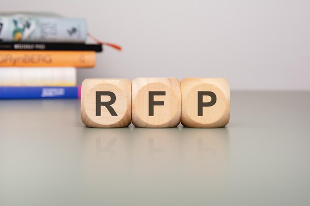 Bloques de madera que muestran letras de RFP contra un diseño de fondo limpio y minimalista