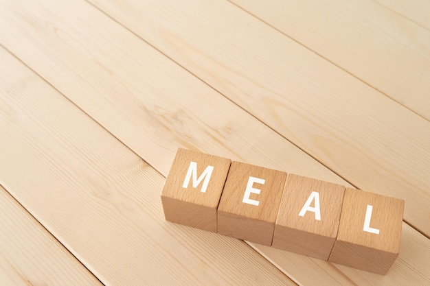 Bloques de madera con texto COMIDA de concepto en el suelo de madera.