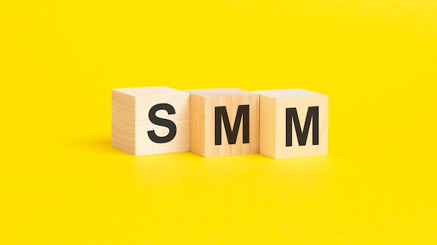 Bloques de madera con texto SMM sobre fondo amarillo concepto de negocio