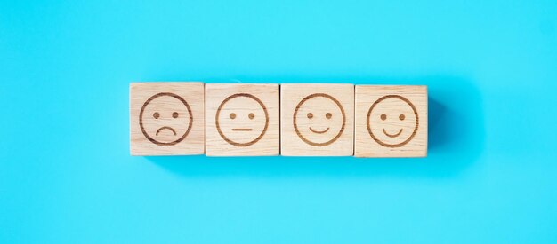 Bloques de símbolos de cara de emoción sobre fondo azul Clasificación de clasificación de servicio evaluación de satisfacción de revisión del cliente y concepto de retroalimentación