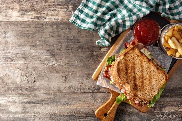 BLT-Sandwich mit Speck, Salat und Tomate auf Holztisch