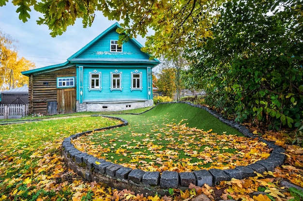 Foto blue cottage of golf club e um campo de golfe em folhas de outono em plyos em um dia de outono