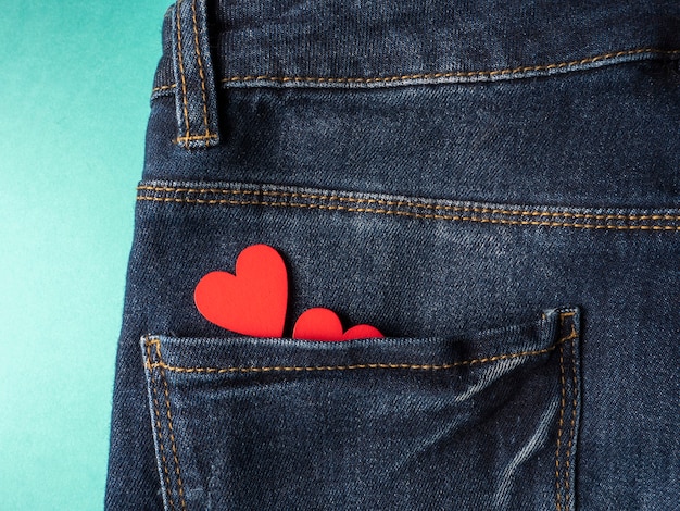 Blue jeans y en el bolsillo trasero de los jeans hay dos corazones rojos sobre verde