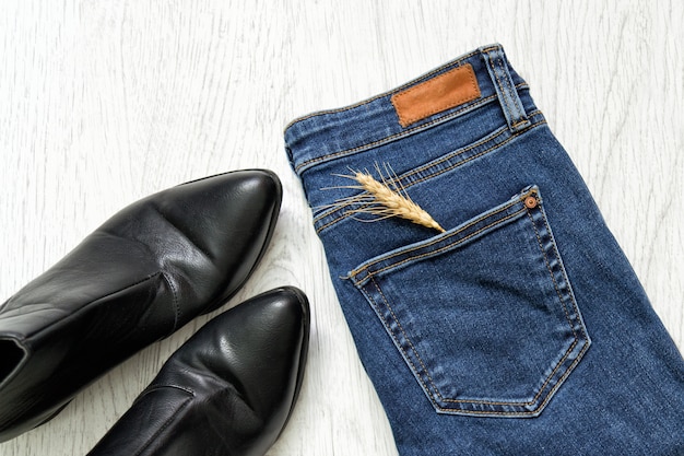 Blue Jeans, schwarze Schuhe und Weizenähre