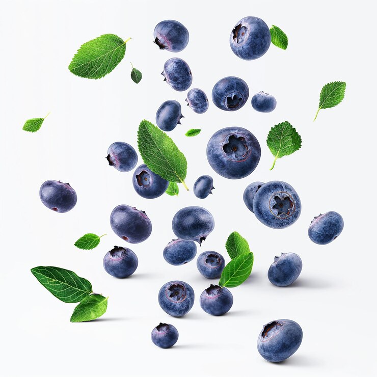 Blueberry con medias rebanadas cayendo o flotando en el aire con hojas verdes sobre un fondo blanco
