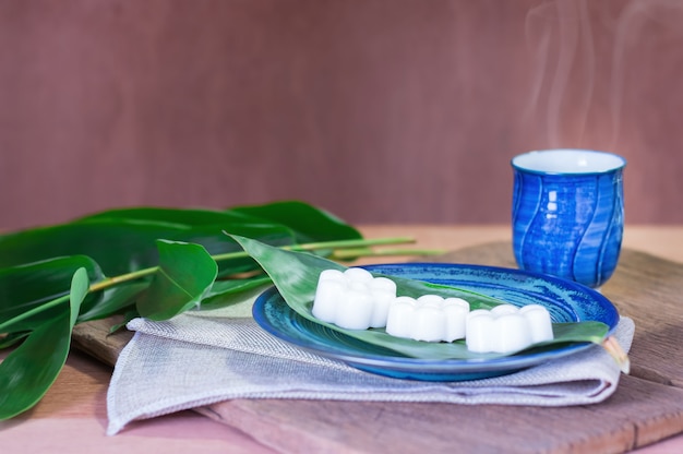 Blühen Sie weiße Kokosnussgelee-Nachtischbonbons von Thailand. Essen Sie mit heißem Tee auf Kattun.