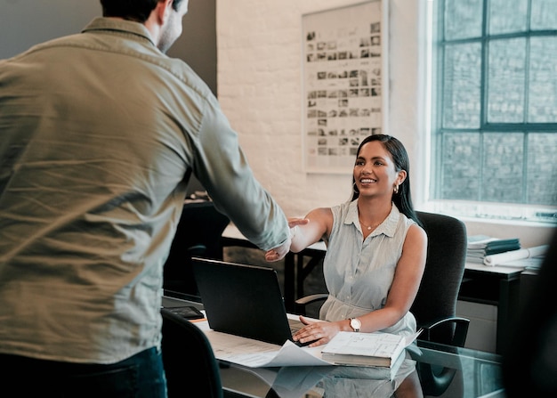 Blueprint laptop e pessoas de negócios em arquitetura com aperto de mão gerenciamento de projeto ou acordo homem e mulher apertando as mãos na mesa para parceria desenvolvimento criativo e introdução