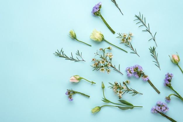 Blütenzusammensetzung von Rosen, Eustoma und Zitronengras auf Blau