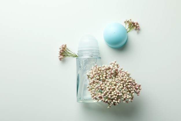 Blume und leeres Deodorant auf weißem Hintergrund