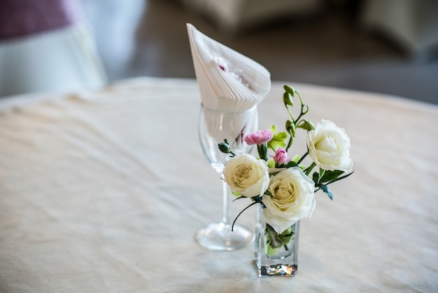 Blumen im Glas auf weißem Stoff für die Zeremonie.