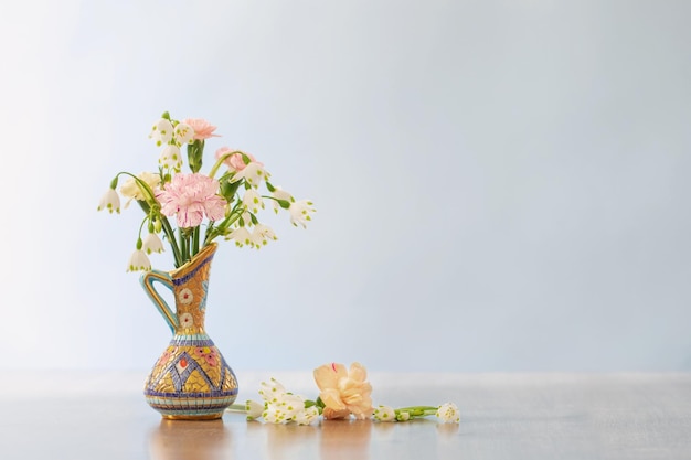 Blumen im Vintage-Krug auf Holztisch auf weißem Hintergrund