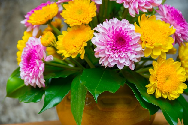 Blumen in einer Vase auf Zementwand. Hintergrundtextur