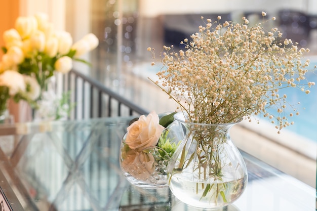 Blumen in einer Vase neben dem Glas am Pool