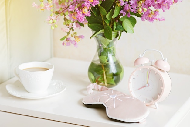 Blumen, Kaffee und Wecker im Schlafzimmer