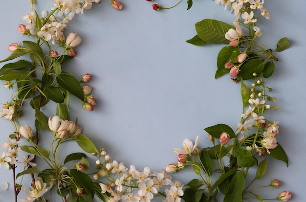 Foto blumen-layout auf einem vintage weißen holz-hintergrund und computer teilweise frühlingsblumen frau freiberufliche konzept sicht von oben