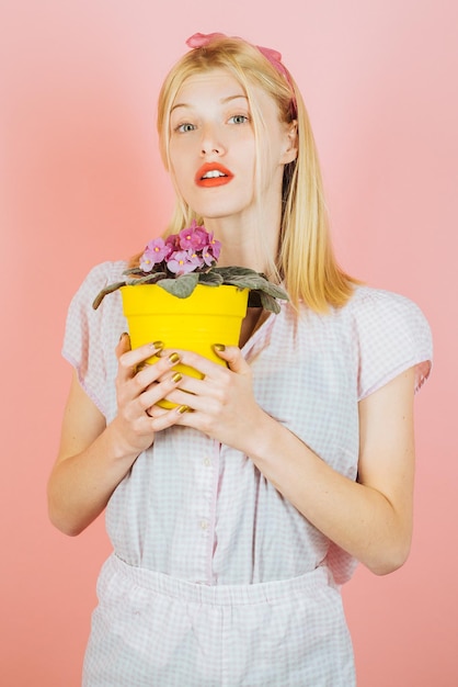 Blumen pflanzenGärtnerin pflanzt Blumen süße blonde Gartenarbeit auf isoliertem Hintergrund