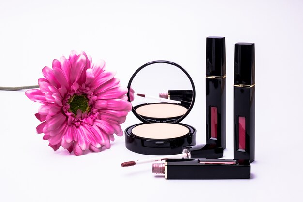 Blumen, Puder und flüssiger Lippenstiftpinsel